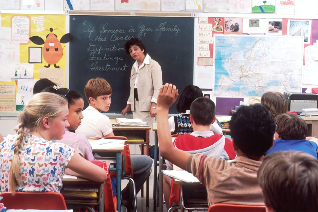 Photo by National Cancer Institute woman standing in front of children